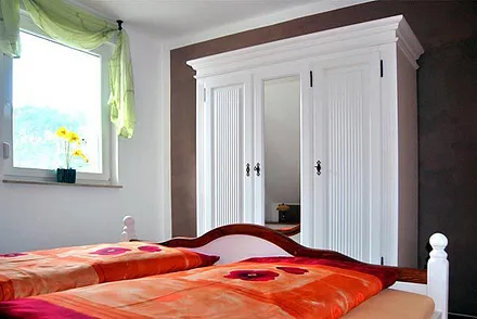 Schlafraum mit Doppelbett und großem Schrank
