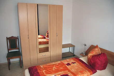 Schlafraum mit Doppelbett und großem Schrank