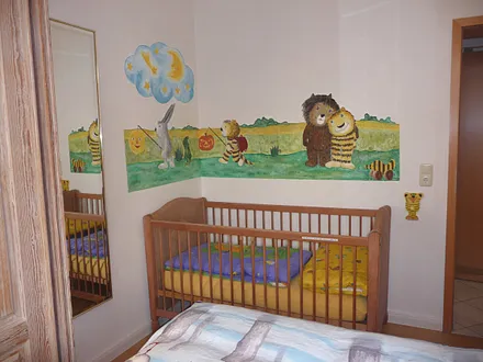 Kinderbett im Elternschlafzimmer mit Janosch-Wandmalerei