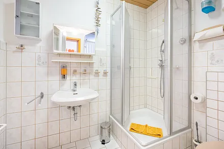 Ein  Duschbad mit WC und Tageslicht.  Einweg -Zahnbecher, Seife, Reinigungsmittel uvm.