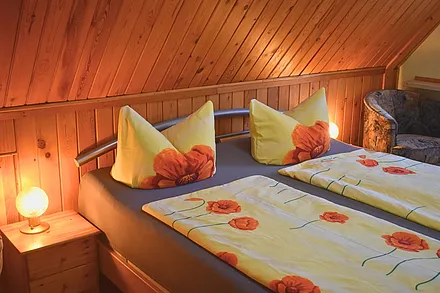 FeWo Knuth - Schlafzimmer mit Nachtschränken, Kommode, TV, Sessel