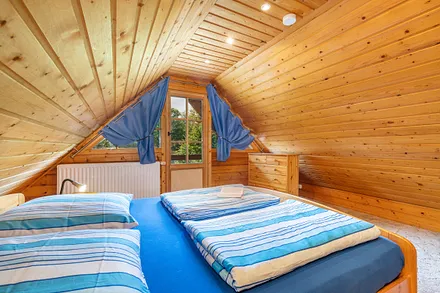 Schlafzimmer 1 hat ein Doppelbett und einen Austritt zum Balkon. Kinderreisebettchen und Hochstuhl werden gern bereit gestellt.