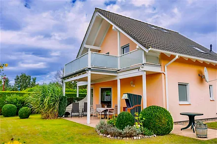 Gartenansicht: Überdachte Terrasse mit Blick in den Garten, rundum Hecken als Sichtschutz