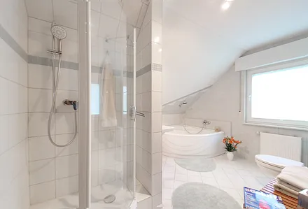 Badezimmer mit Badewanne und Dusche