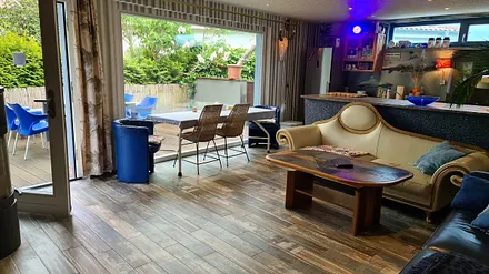 Wohnzimmer mit Kamin, Küche und Terrasse