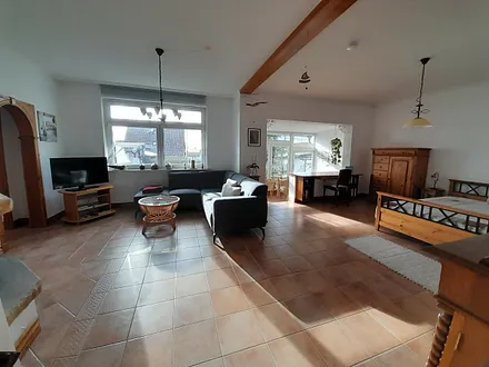 Wohn-Schlafraum mit Sitzgarnitur am Kamin, Schreibtisch, Wintergarten und Doppelbett