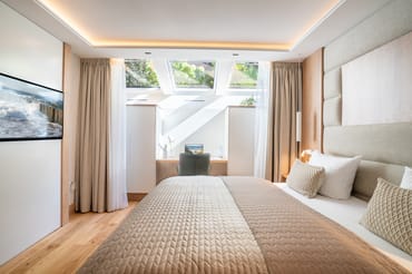 Schlafzimmer mit Smart TV, Schreibtisch und Bad en Suite