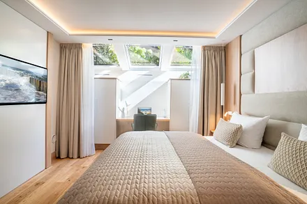 Schlafzimmer mit Smart TV, Schreibtisch und Bad en Suite