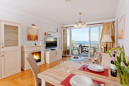 Ess- und Wohnbereich mit Bioethanolkamin und Balkon mit Meerblick