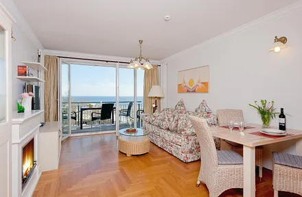 Ess- und Wohnbereich mit Bioethanolkamin und Balkon mit Meerblick