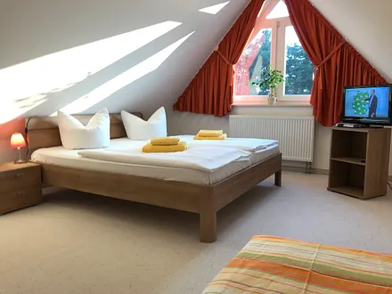 großes , sehr schönes Schlafzimmer im Dachgeschoss mit einem großen Doppelbett und einem zusätzlichen Einzelbett , SAT-TV , erreichbar durch Treppe