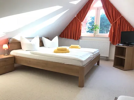 großes , sehr schönes Schlafzimmer im Dachgeschoss mit einem großen Doppelbett und einem zusätzlichen Einzelbett , SAT-TV , erreichbar durch Treppe