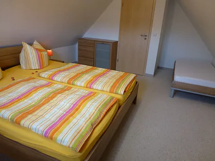 Schlafzimmer 2 mit Doppelbett und 1 Einzelbett und SAT-TV im Dachgeschoss