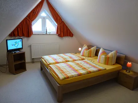 Schlafzimmer 2 mit Doppelbett und 1 Einzelbett und SAT-TV im Dachgeschoss
