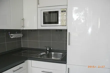 Küche mit Kühl-Gefrierkombination, Geschirrspüler und Mikrowelle