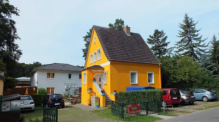 Die Ferienwohnung befindet sich im gelben Haus im OG