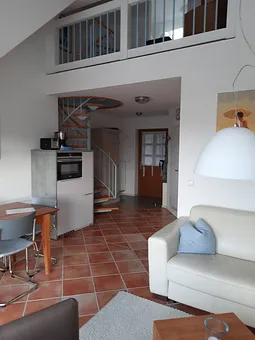 offener Wohnbereich mit Wendeltreppe in den oberen Schlafbereich