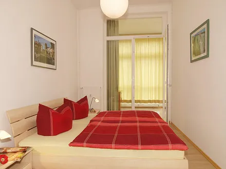 Schlafzimmer mit Doppelbett und ebenfalls mit Zugang zur sonnigen Loggia