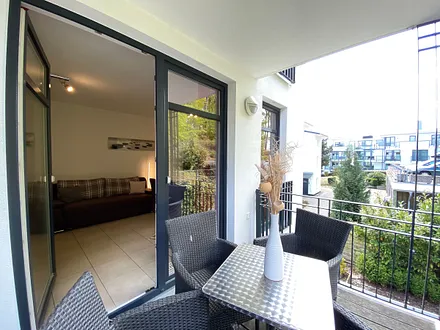 bestuhlter Balkon mit Blick ins Wohnzimmer