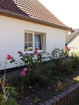 Seitenansicht des Hauses mit Blick aufs Wohnzimmerfenster der Ferienwohnung 