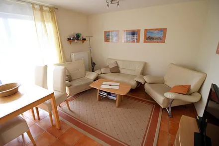 Wohnzimmer hat  bodentiefe Fenster und elektrische Aussenrollos. 