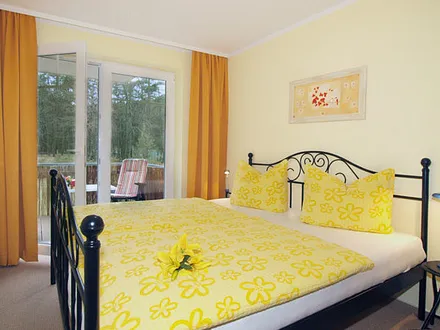 Schlafzimmer mit Doppelbett und Zugang zum Balkon