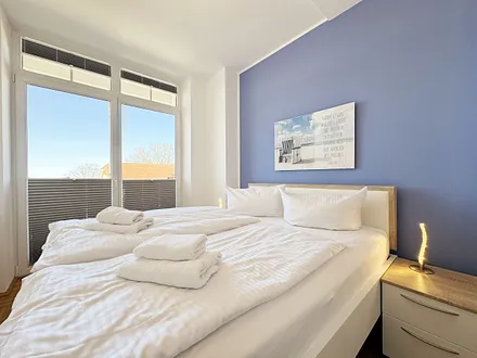 Schlafzimmer mit Doppelbett und Nachttischablagen