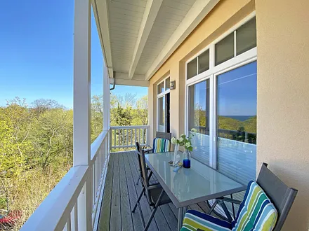bestuhlter Balkon mit seitlichem Blick Richtung Wald