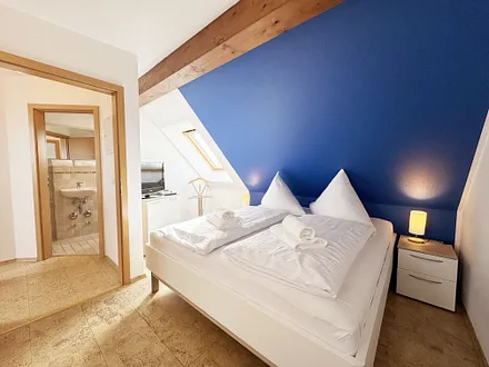 Schlafzimmer mit Doppelbett und Smart-TV