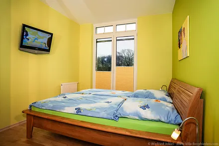 Schlafzimmer 1 mit Doppelbett und Fernseher