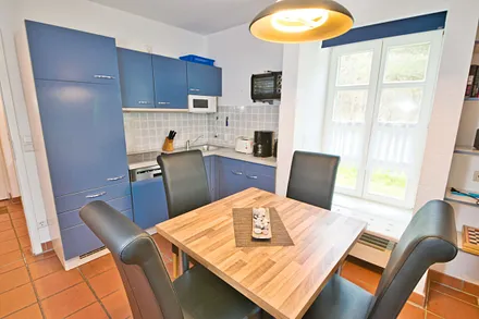 Komplett ausgestattete Einbauküche und Esstisch mit 4 Stühlen.