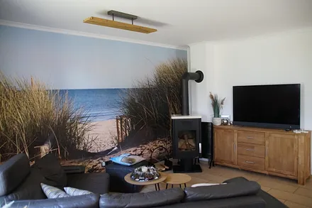Der Wohnbereich mit gemütlicher Sitzgruppe, Kamin und LED Ambilight Fernseher