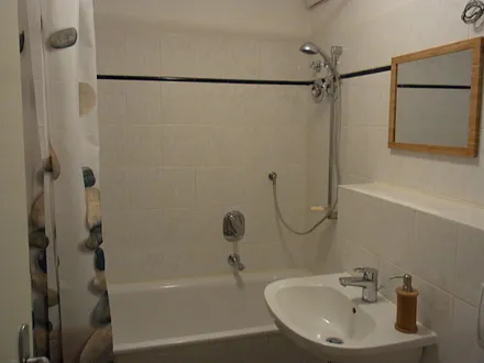 Bad mit Badewanne und Duschvorrichtung.