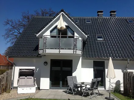 Die Süd-West Terrasse, ausgestattet mit Tisch/Relaxstühlen, Sonnenschirm und Strandkorb. 