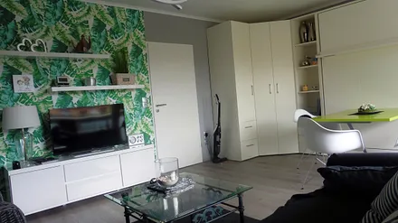 Low Board mit TV gegenüber Sofa und Sesseln