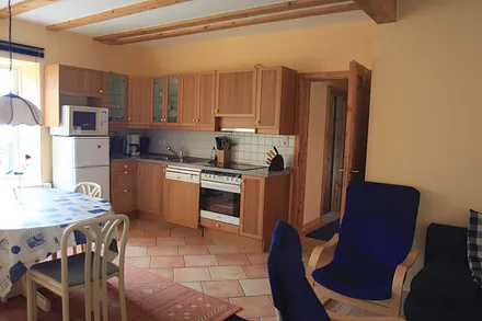 Küchenzeile mit Heißluftherd und Ceranfeld, Mikrowelle, Kühl-Gefrierkombination und Geschirrspüler. Außerdem Esstisch für 6 Personen mit Ostseeblick.