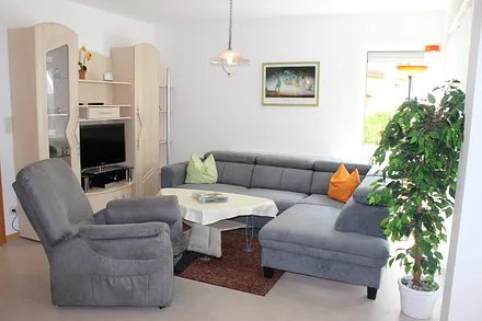 Der Wohnbereich mit bequemer Eckcouch mit zwei einzeln ausziehbaren Federkernbetten, Sessel, Leselampe und großem Fernseher