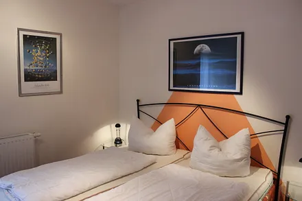 Schlafzimmer mit Doppelbett, Nachttischen, Leselampen und geräumigem Kleiderschrank