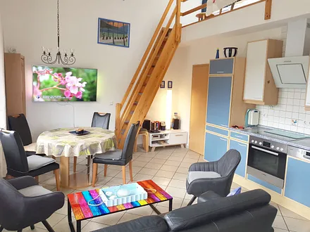 Essbereich mit großem 55'' Fernseher und Küche mit modernen Geräten