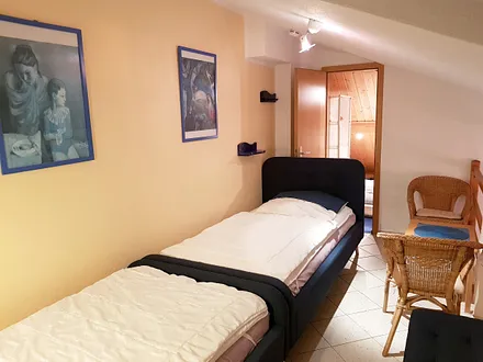 Galerie mit zwei Einzelbetten und angrenzender Spielhöhle