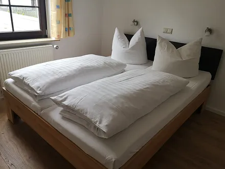 Im Schlafzimmer befindet sich ein Doppelbett. Es ist Platz für ein Babybett bzw. eine Matratze für ein Aufbettung Kind.