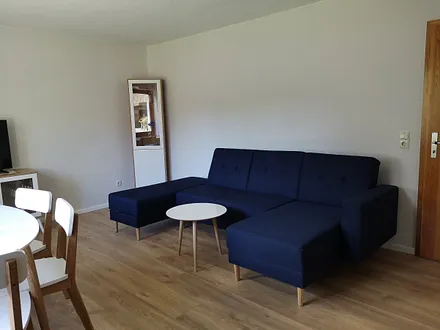 Das Wohnzimmer hat ein Fenster zur Südseite. Sie können mit Blick auf den Hof frühstücken oder auch auf dem Hof im Grünen sitzen.