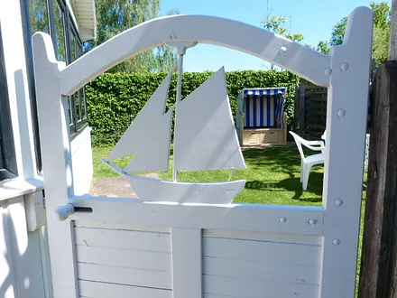 Eingang zum Ferienhaus und Garten mit gemütlicher Sitzgelegenheit