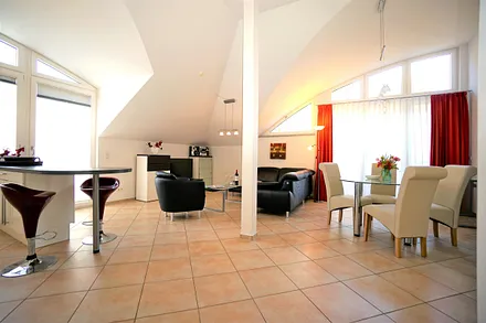 Geräumiges Wohnzimmer mit Esstisch und offener Küche