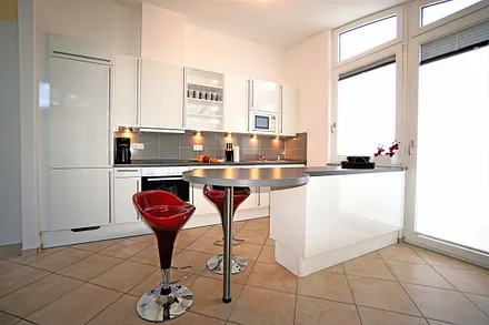 Voll ausgestattete Küchenzeile mit Tür zum kleinen Balkon