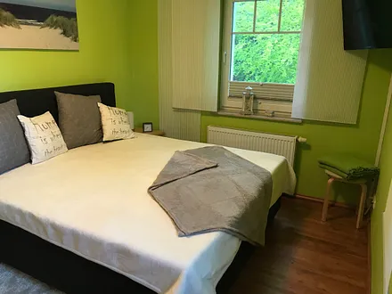Schlafzimmer mit Boxspringbett, großem Schrank und TV