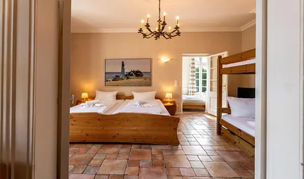 Schlafzimmer mit großem Doppelbett und Etagenbett