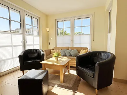 gemütliches Wohnzimmer mit Couch und Sessel