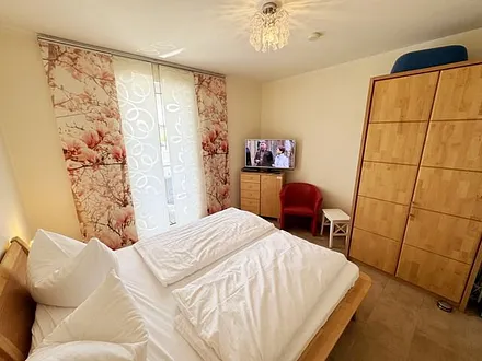 Schlafzimmer mit Doppelbett (2x 0,80 m x 2,00 m), Kleiderschrank, Wäschekommode, Sessel und LED-TV mit DVD