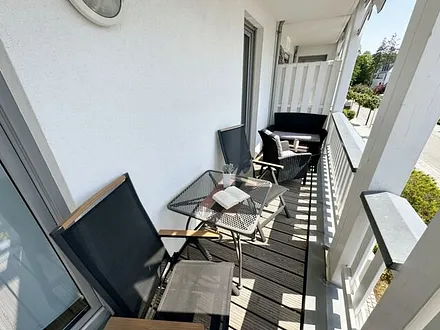 bestuhlter Balkon mit einem Tisch, 2 Stühlen sowie einer gemütlichen Sitzgruppe